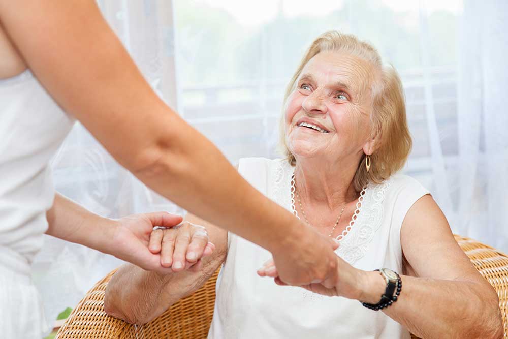 Personal care aide assisting an elderly woman at home