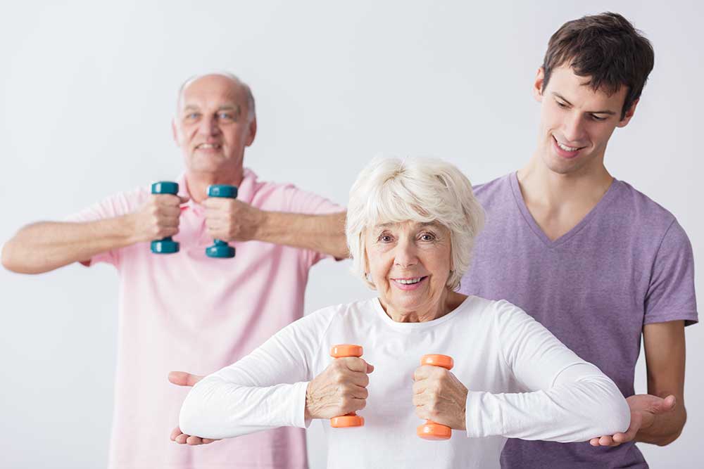 Home health aide supporting seniors with light exercise